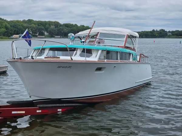 The Image of 1961 Chris-Craft Roamer boat on water, featuring classic design and vibrant accents. - 0