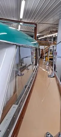 Slide: The Image of 1961 Chris-Craft Roamer boat in a workshop, showcasing sleek design and polished surfaces. - 11