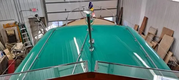 Slide: The Image of 1961 Chris-Craft Roamer boat with teal deck in a workshop setting. - 12