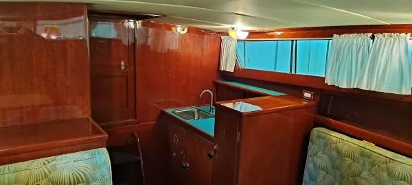 Slide: The Image of 1961 Chris-Craft Roamer interior with wood paneling, sink, and seating area. - 13