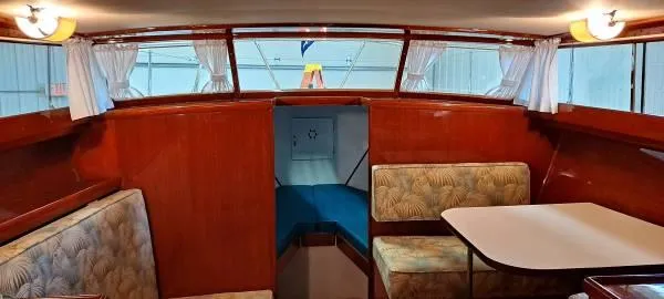 Slide: The Image of 1961 Chris-Craft Roamer interior with wood paneling, dining area, and cozy seating. - 15