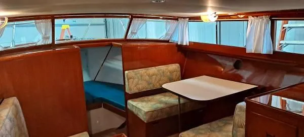Slide: The Image of 1961 Chris-Craft Roamer interior with wood paneling, dining area, and cozy seating. - 16
