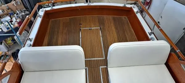 Slide: The Image of 1961 Chris-Craft Roamer boat deck with teak flooring and white cushioned seating. - 18