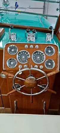 Slide: The Image of 1961 Chris-Craft Roamer boat dashboard with vintage gauges and wooden steering wheel. - 19