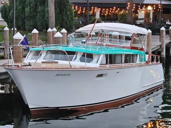 Slide: The Image of 1961 Chris-Craft Roamer boat docked, featuring classic design and turquoise accents. - 4