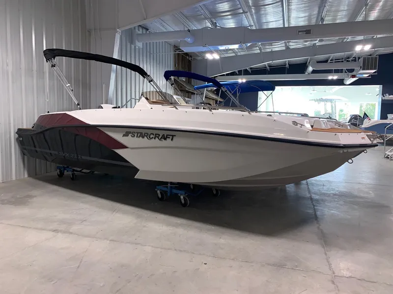 Slide: The Image of 2024 Starcraft SVX 211 boat in showroom, side view. - 0