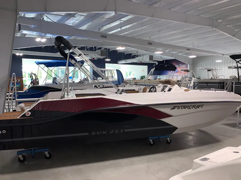 Slide: The Image of 2024 Starcraft SVX 211 boat displayed in a showroom. - 1