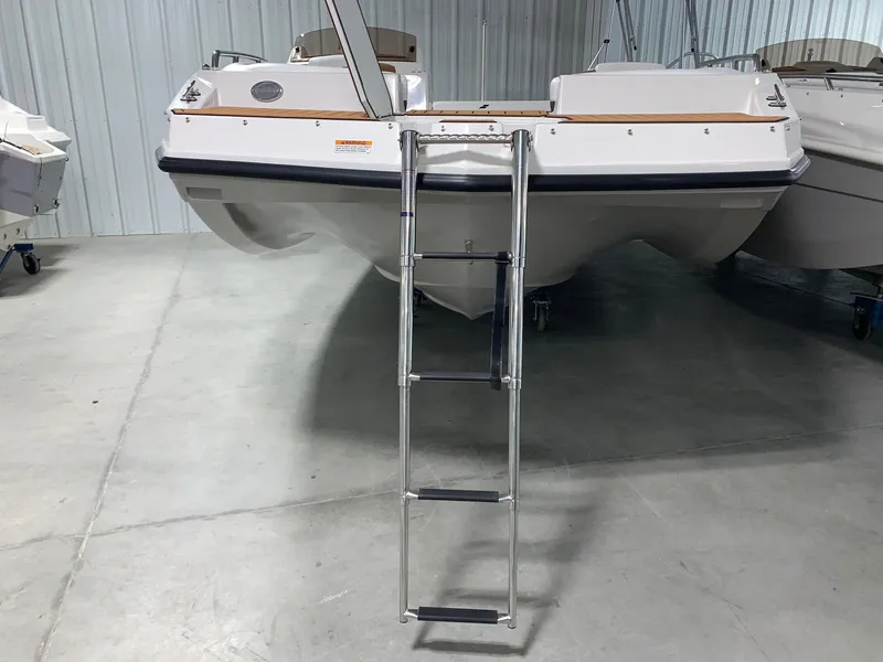 Slide: The Image of 2024 Starcraft SVX 211 boat with a ladder in a showroom. - 12