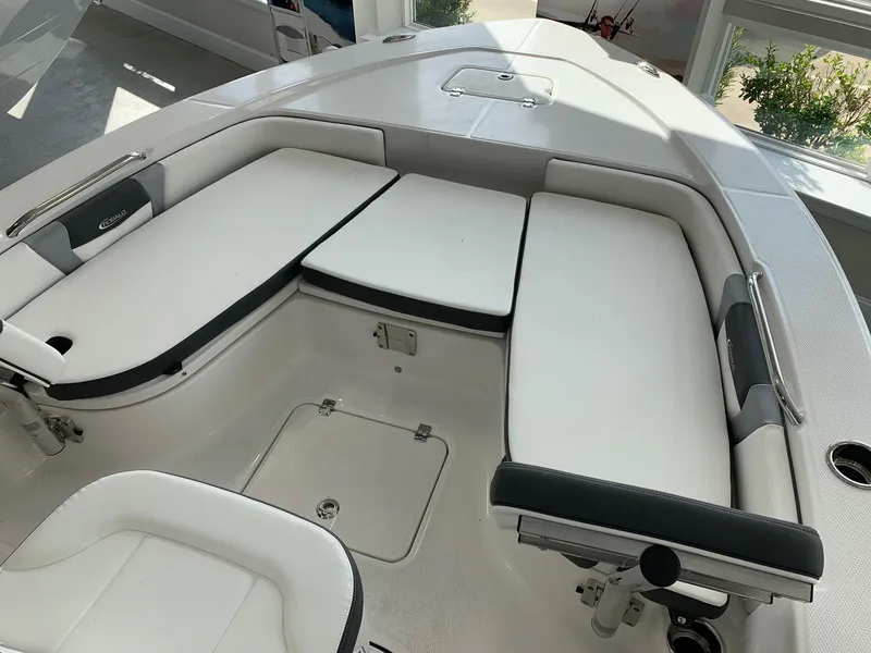 Slide: The Image of 2024 Robalo 226 Cayman boat interior with cushioned seating and storage compartments. - 13