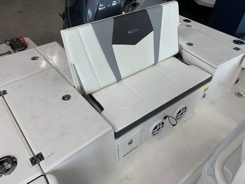 Slide: The Image of 2024 Robalo 226 Cayman boat seating area with storage compartments and speakers. - 6