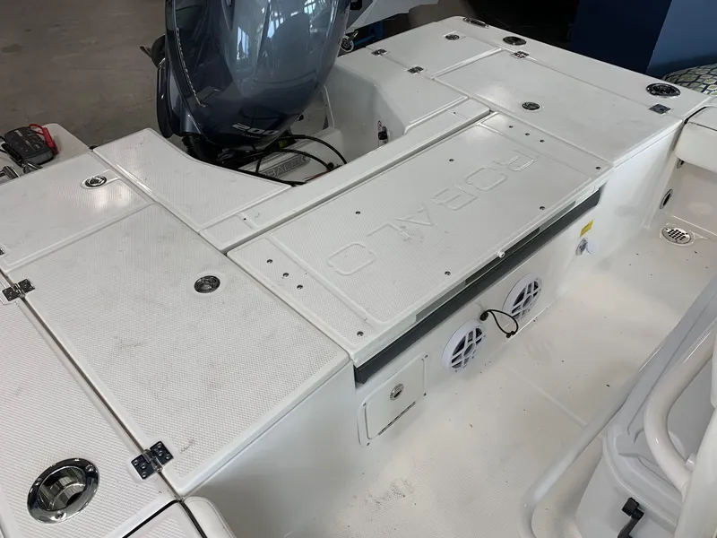 Slide: The Image of 2024 Robalo 226 Cayman boat deck with storage compartments and outboard motor. - 7