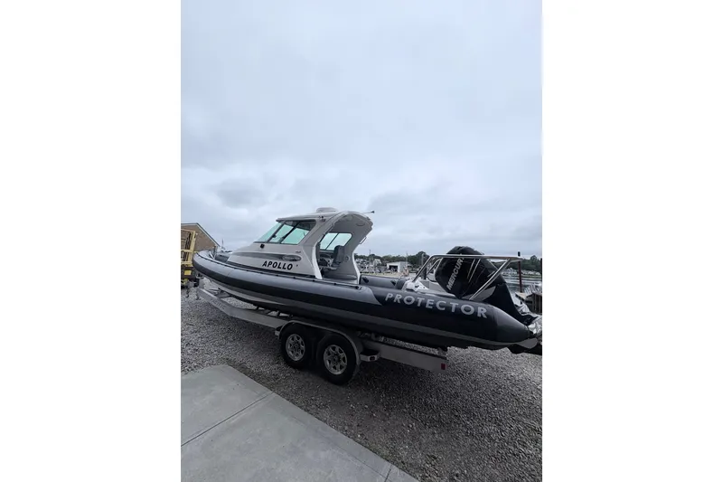 Slide: The Image of 2012 Protector Targa 30 boat on trailer, overcast sky background. - 3