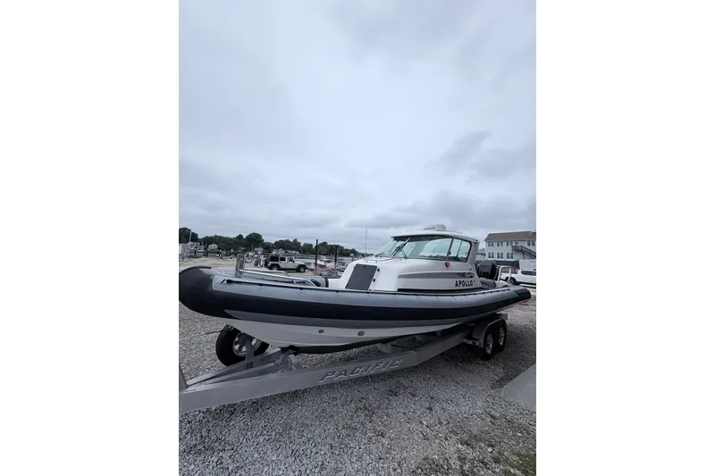 Slide: The Image of 2012 Protector Targa 30 boat on trailer, parked outdoors under cloudy sky. - 13