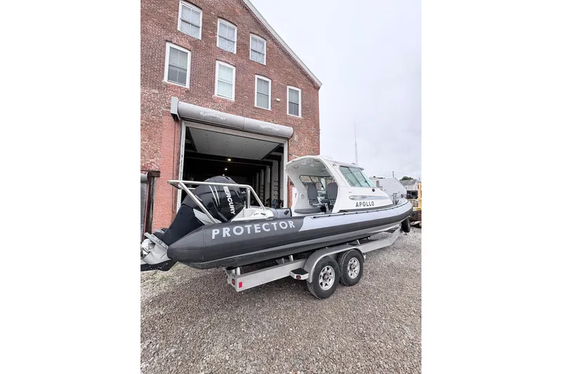 Slide: The Image of 2012 Protector Targa 30 boat on trailer outside brick building. - 2