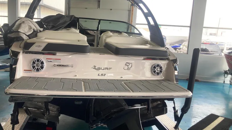 Slide: The Image of 2021 Regal LS2 Surf boat in showroom, rear view with speakers and swim platform. - 12