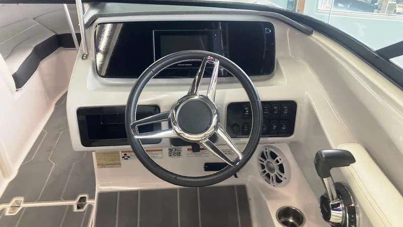 Slide: The Image of 2021 Regal LS2 Surf boat dashboard with steering wheel and control panel. - 6