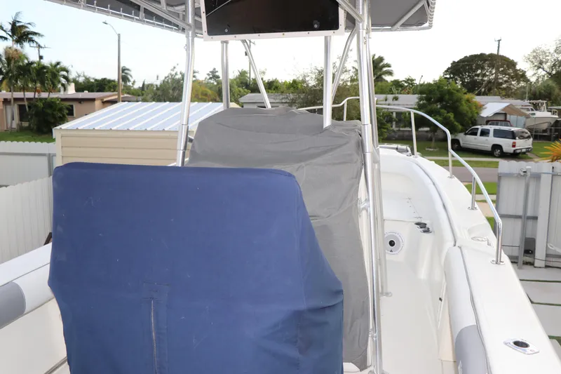 Slide: The Image of 2001 Boston Whaler Outrage 26 CC boat with covered seating, parked in a residential area. - 24