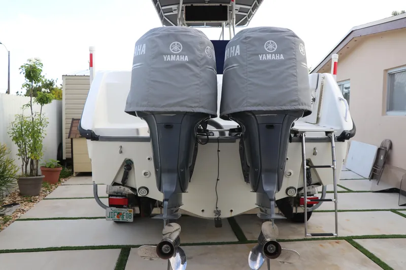 Slide: The Image of 2001 Boston Whaler Outrage 26 CC with twin Yamaha outboard motors, parked in driveway. - 25