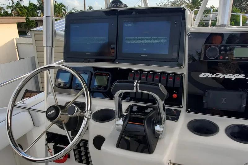 Slide: The Image of 2001 Boston Whaler Outrage 26 CC helm with dual screens and steering wheel. - 7