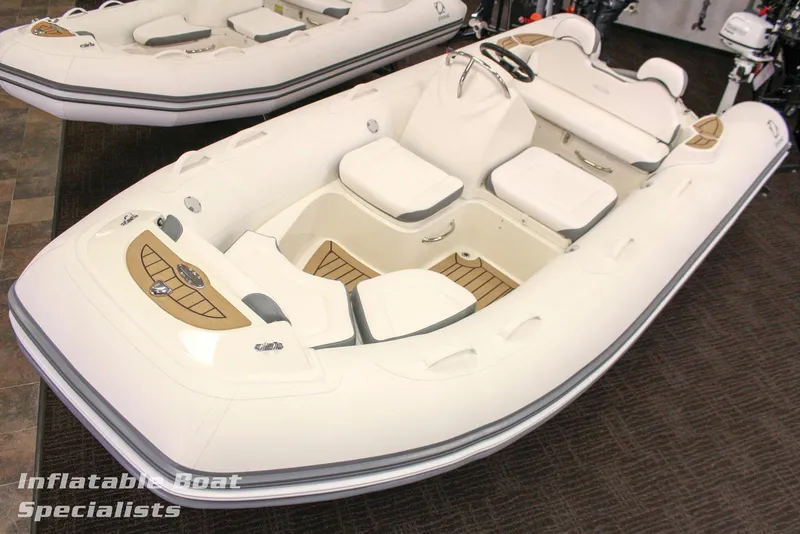 The Image of 2024 Zodiac Yachtline 490 inflatable boat with white seating and wood accents. - 0