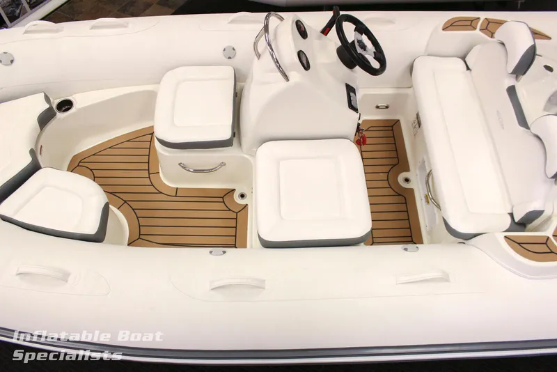 Slide: The Image of 2024 Zodiac Yachtline 490 inflatable boat interior with white seating and teak flooring. - 6