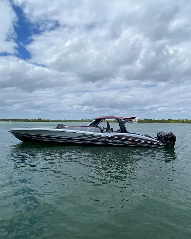 The Image of 2025 MTI V50 boat cruising on a calm lake under a partly cloudy sky. - 0
