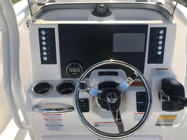Slide: The Image of 2024 Robalo R200 Center Console boat dashboard with steering wheel and control panel. - 3