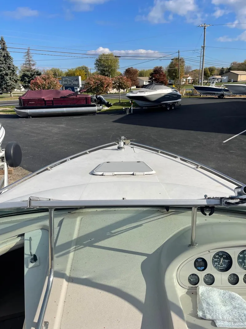 Slide: The Image of 1992 Regal Ventura boat with dashboard view, parked outdoors under a clear blue sky. - 11