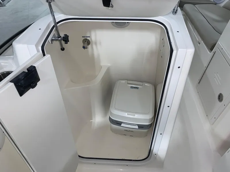 Slide: The Image of 2024 Key West 203 DFS boat interior with portable toilet and storage compartment. - 8