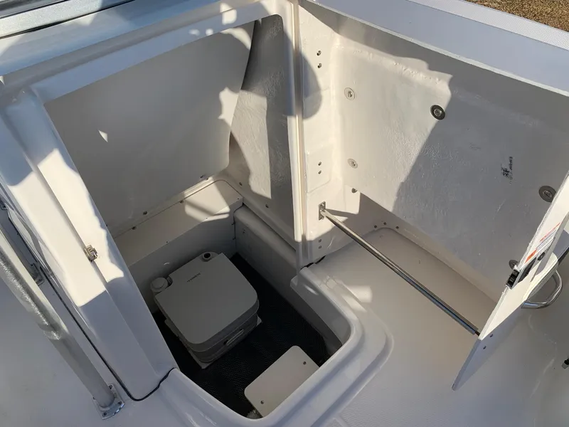 Slide: The Image of 2024 Robalo R202 Explorer boat interior storage compartment with portable toilet. - 12