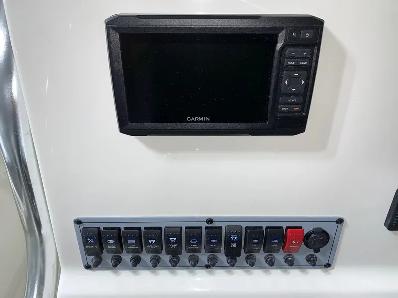 Slide: The Image of 2024 Key West 219 FS boat control panel with Garmin display and switches. - 13