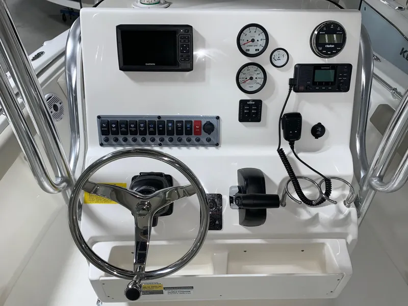 Slide: The Image of 2024 Key West 219 FS boat console with steering wheel, gauges, and electronic controls. - 14