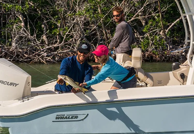Slide: The Image of People fishing on a 2023 Boston Whaler 220 Dauntless boat. - 4