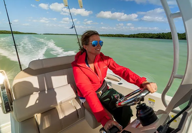 Slide: The Image of Woman driving 2023 Boston Whaler 250 Dauntless boat on a sunny day. - 4