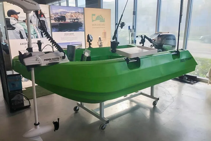 Slide: The Image of Green 2021 Polycraft 300 Tuffy boat displayed indoors with fishing equipment. - 2