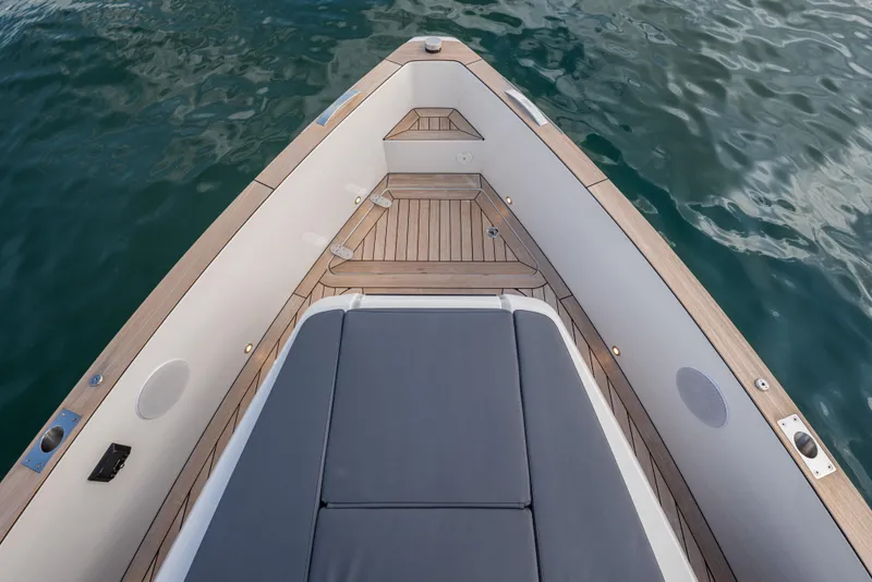 Slide: The Image of 2024 Fjord 41 XL boat deck with sleek wood finish and cushioned seating. - 25