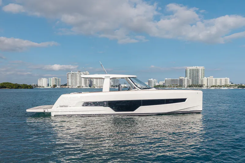 Slide: The Image of 2024 Fjord 41 XL yacht cruising on water with city skyline in background. - 26