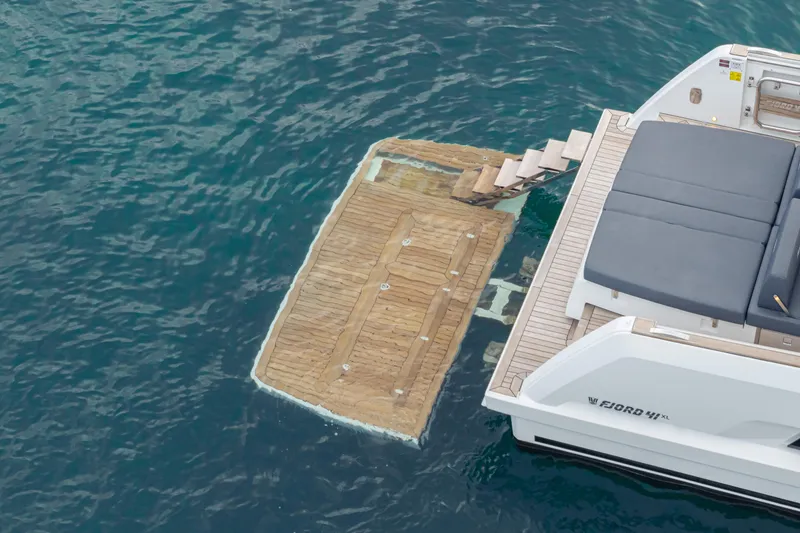 Slide: The Image of 2024 Fjord 41 XL yacht with swim platform and sunbed on calm water. - 28