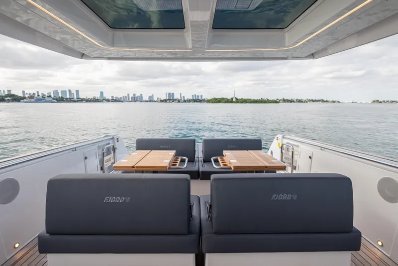 Slide: The Image of 2024 Fjord 41 XL yacht interior with city skyline view, featuring luxurious seating and tables. - 33