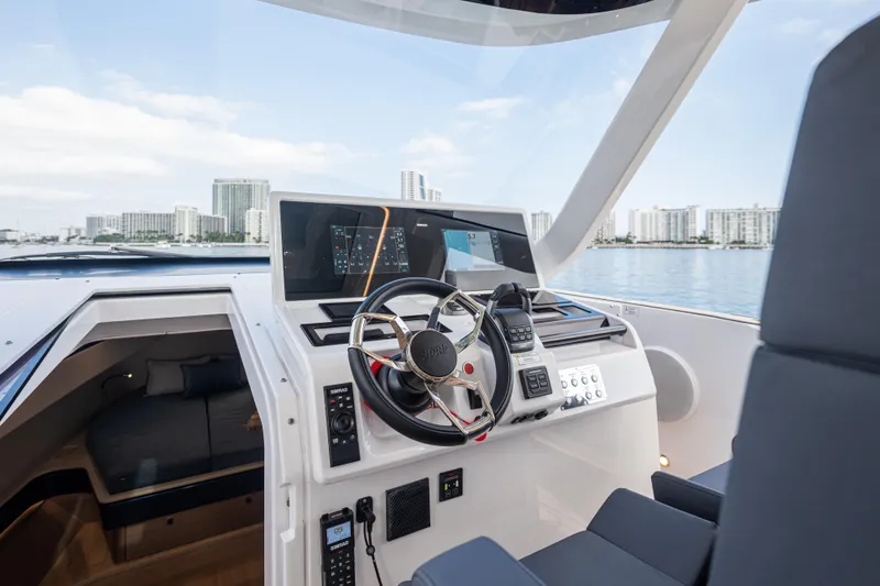 Slide: The Image of 2024 Fjord 41 XL yacht cockpit with modern controls, overlooking city skyline and water. - 34