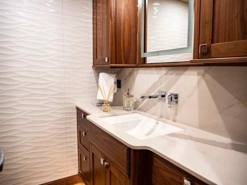 Slide: The Image of Luxurious bathroom in 2025 Northern Marine 57 Expedition yacht with modern fixtures and wooden cabinetry. - 14