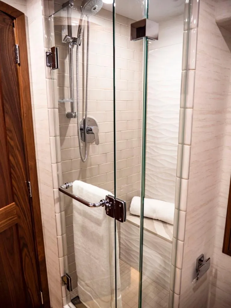 Slide: The Image of Modern shower in 2025 Northern Marine 57 Expedition yacht with glass doors and wooden accents. - 17