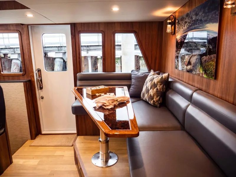 Slide: The Image of Luxurious interior of 2025 Northern Marine 57 Expedition yacht with wooden table and plush seating. - 49