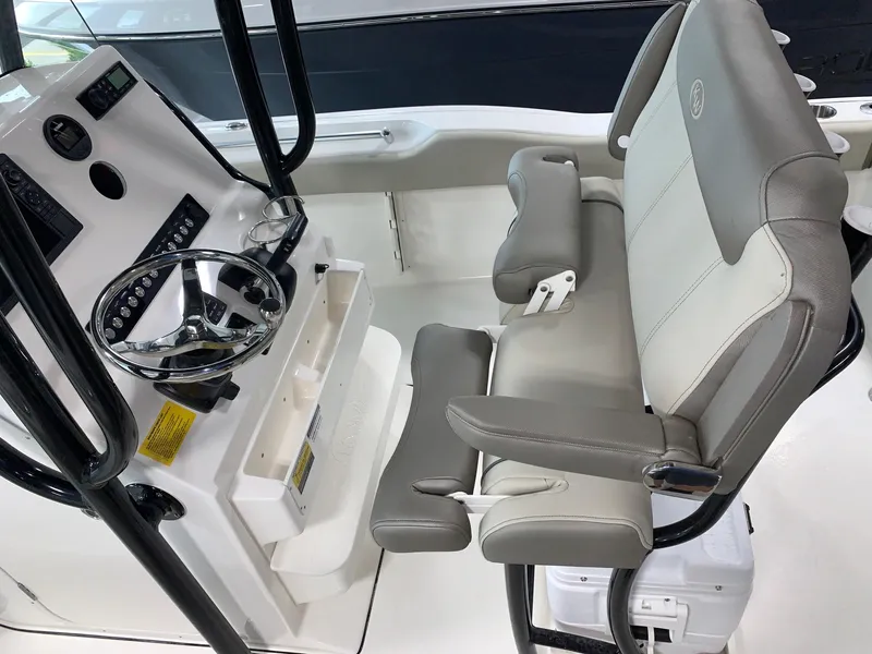 Slide: The Image of 2024 Key West 219 FS boat interior with steering console and cushioned seating. - 10