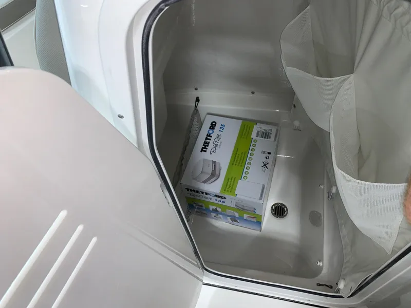Slide: The Image of 2024 Key West 219 FS storage compartment with portable toilet box. - 11