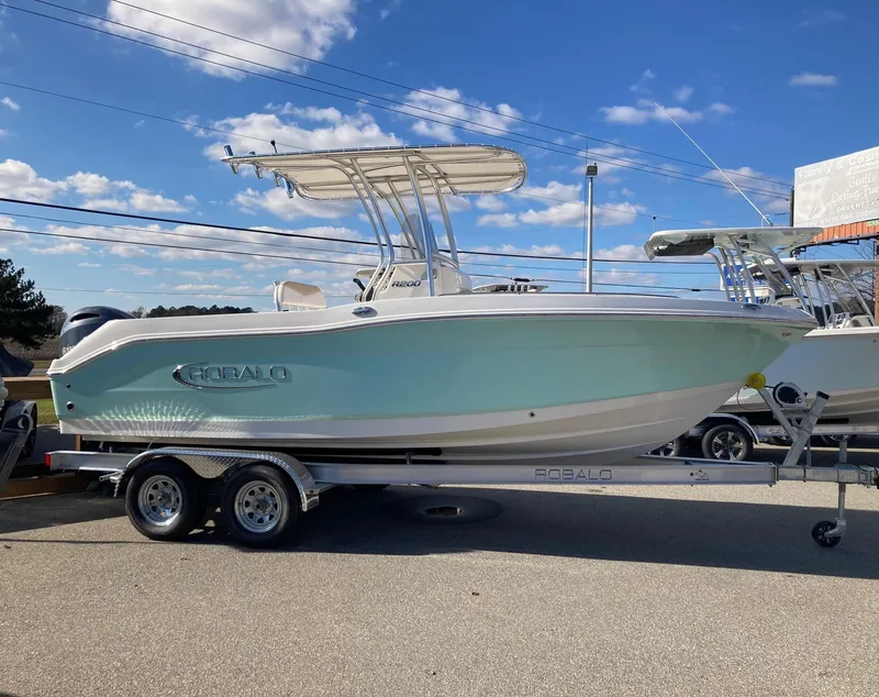 Slide: The Image of 2024 Robalo R200 Center Console boat on a trailer under a clear blue sky. - 1