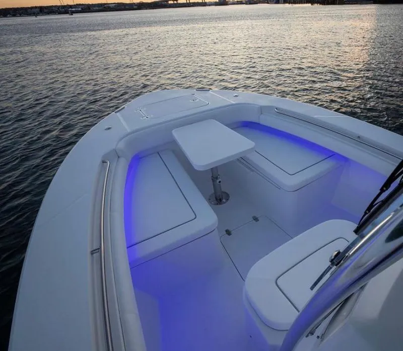 Slide: The Image of 2024 Southport 27 boat with illuminated seating area and table on calm water. - 3