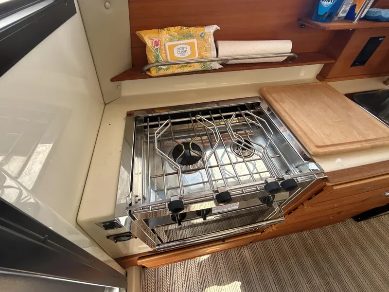 Slide: The Image of Compact kitchen in 2020 Ranger Tugs R-27 boat with stove and cutting board. - 11