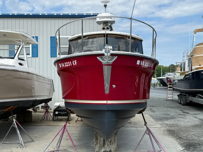 Slide: The Image of 2020 Ranger Tugs R-27 boat in dry dock, vibrant red hull, front view. - 3