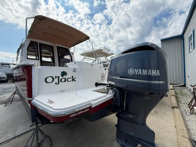 Slide: The Image of 2020 Ranger Tugs R-27 boat with Yamaha outboard motor, docked under a cloudy sky. - 4
